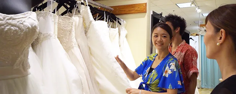 ハワイのサロンで豊富なウェディングドレスの中からスタッフと一緒にドレス選びをする様子
