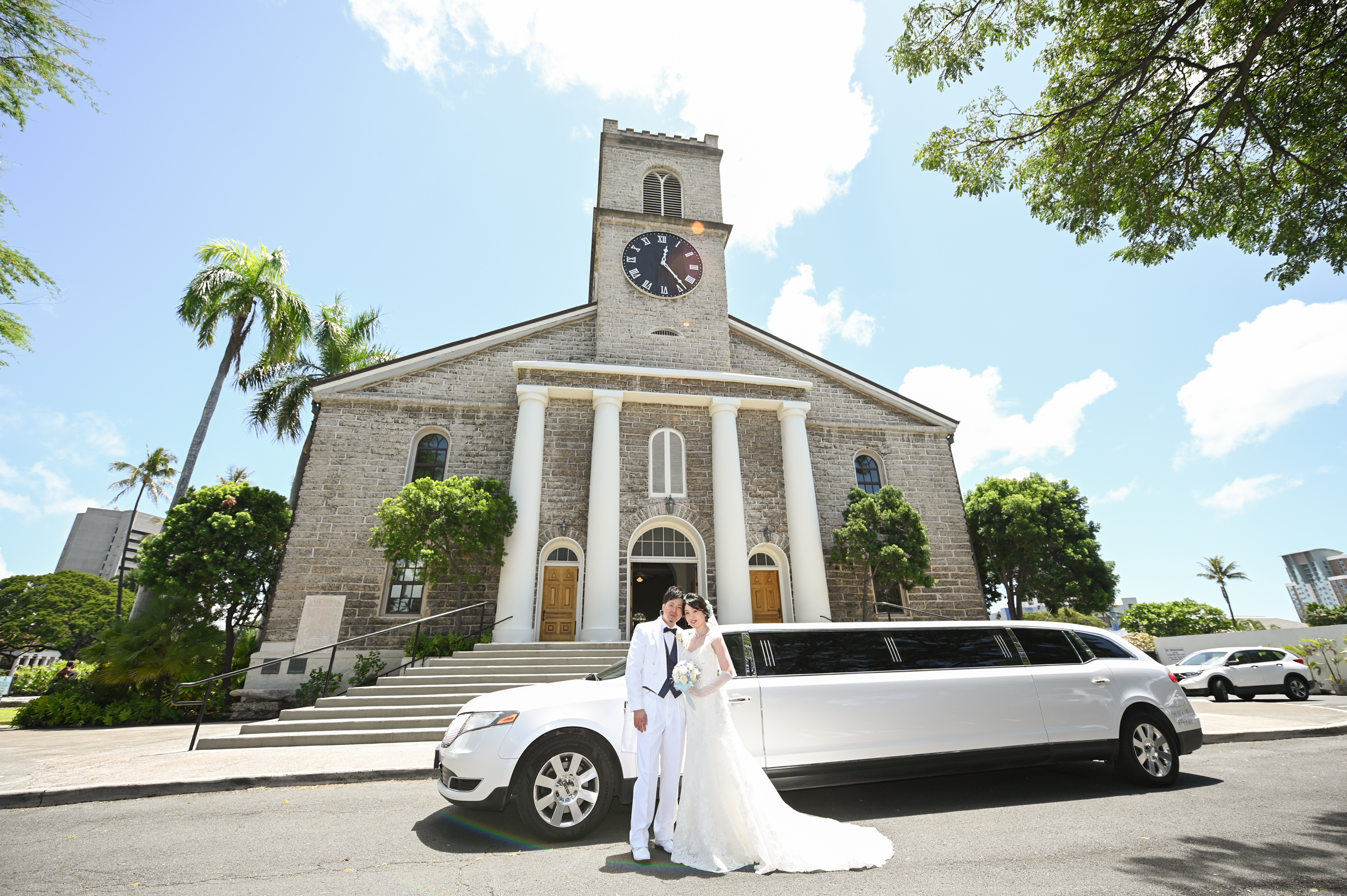 教会の前でリムジンと新郎新婦の写真