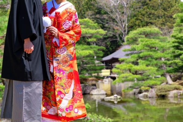 日本庭園を背景にした和装の新郎新婦のウェディングフォト