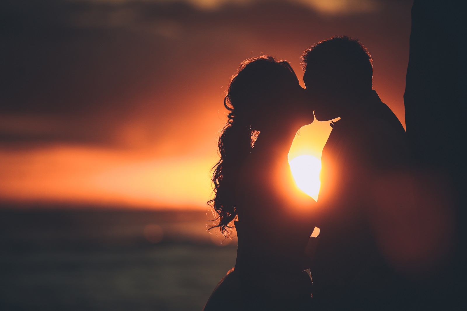 サンセットビーチでキスをしている二人のブライダルフォト