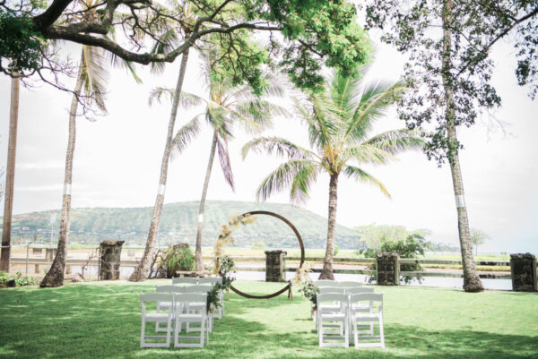 ハワイ・マウロアガーデンのセレモニースペース｜ヤシの木とココヘッドを背景にサークルアーチと白い椅子が並ぶガーデンウェディングの会場