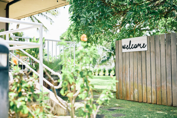 マウロアガーデンの入口｜手書き風のwelcomeサインと緑あふれるプライベートガーデンへのアプローチ