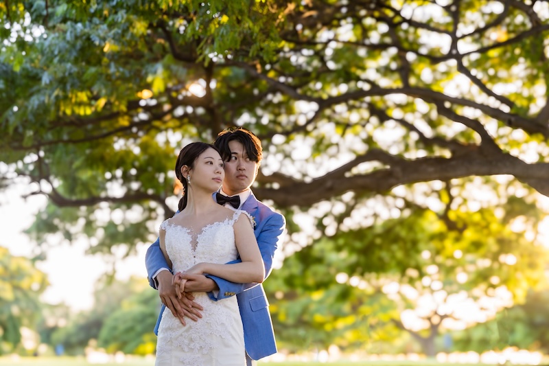 マジックアイランドで撮影したサンセットウェディングフォト。17時半のマジックアワーに空と海がオレンジ色に染まる中、寄り添う新郎新婦のシルエット